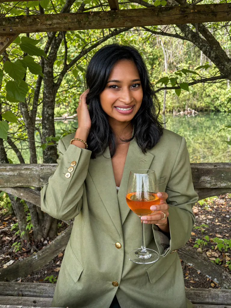 Rushmi, Melbourne marriage celebrant, outdoors with a glass of wine.